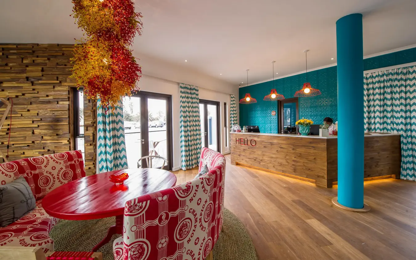 Colorful modern lobby with turquoise accents and red seating, The Delight Swakopmund, Swakopmund, Namibia