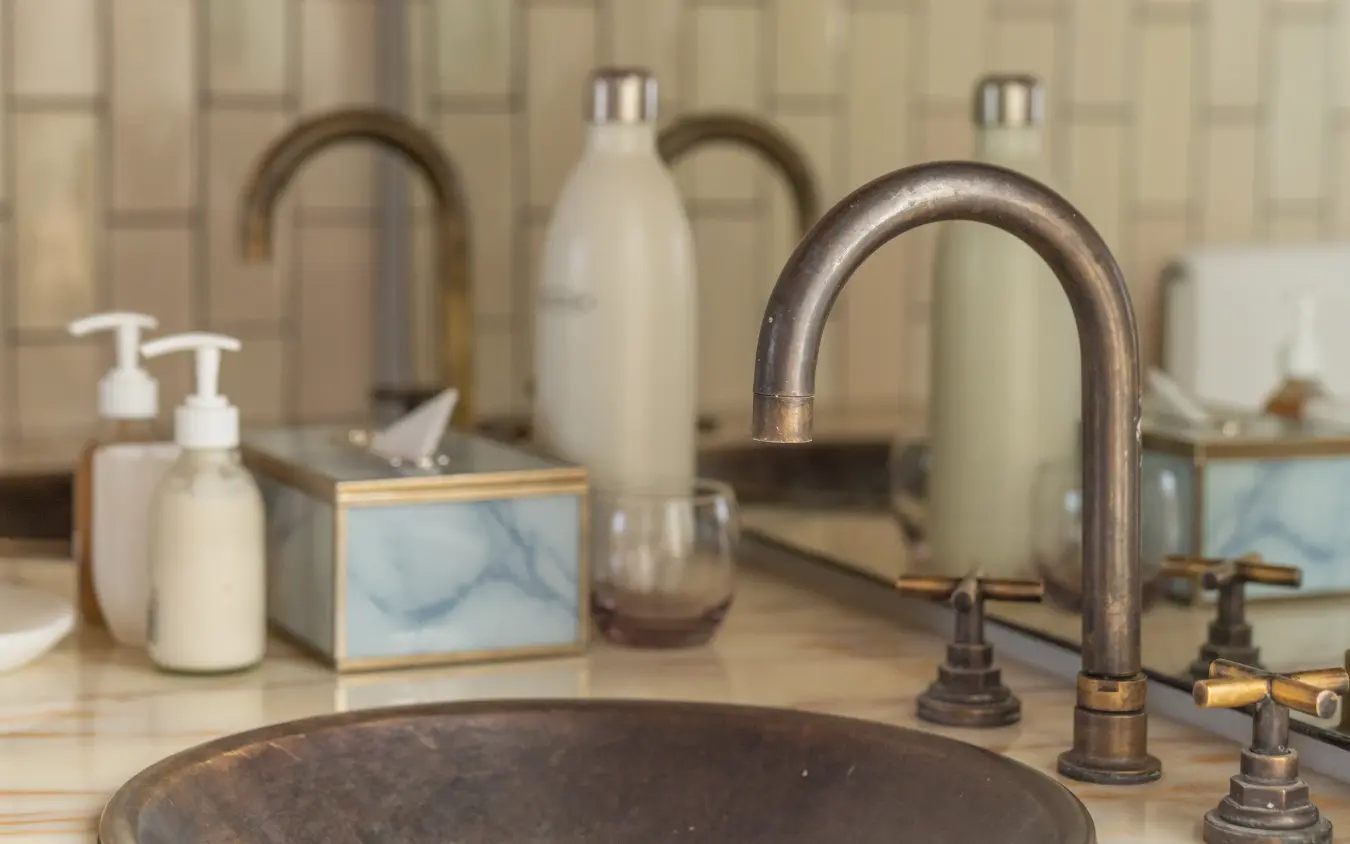 Luxury bathroom vanity with dark stone basin and bronze faucet fixtures, The Desert Grace, Sossusvlei, Namibia