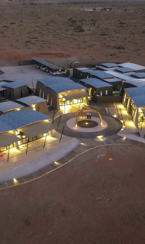 Luxury desert lodge illuminated at dusk with central courtyard and pavilions, The Desert Grace, Sossusvlei, Namibia