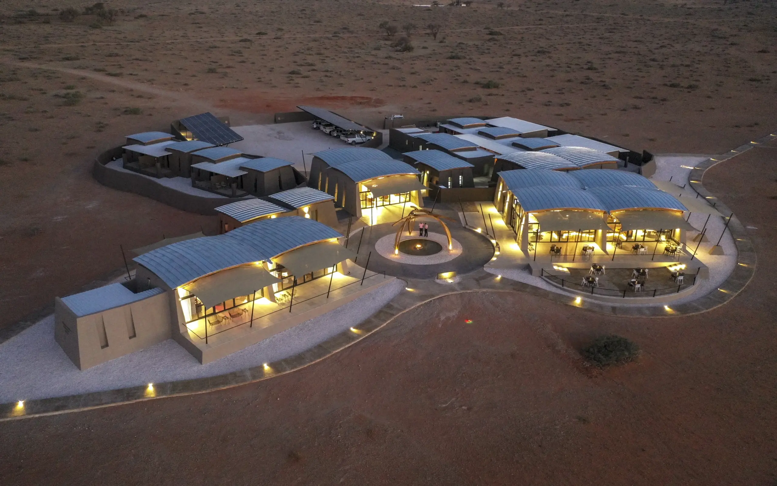 Luxury desert lodge illuminated at dusk with central courtyard and pavilions, The Desert Grace, Sossusvlei, Namibia