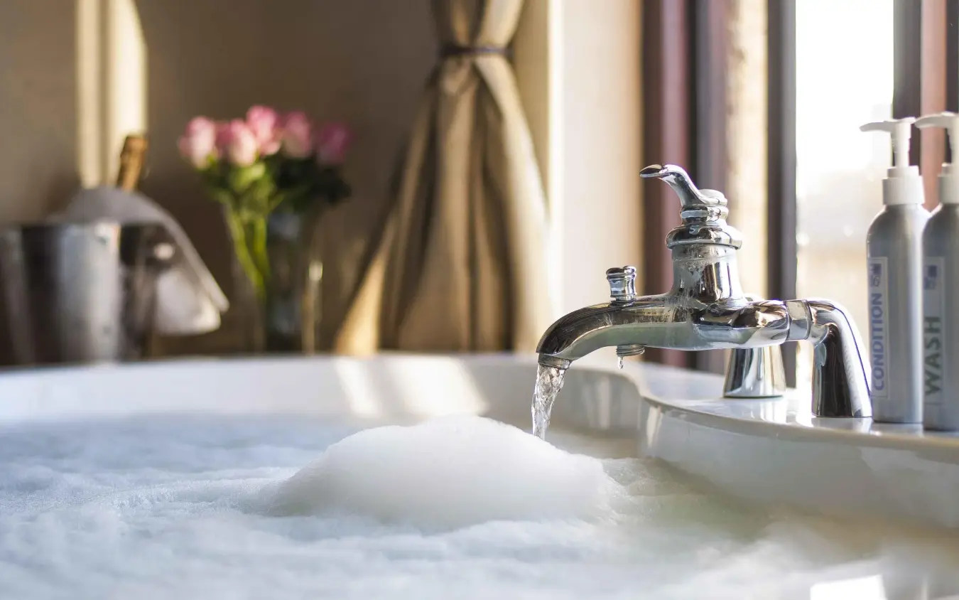 Luxury bathroom sink with flowing water and amenities, The Emakoko, Nairobi, Kenya