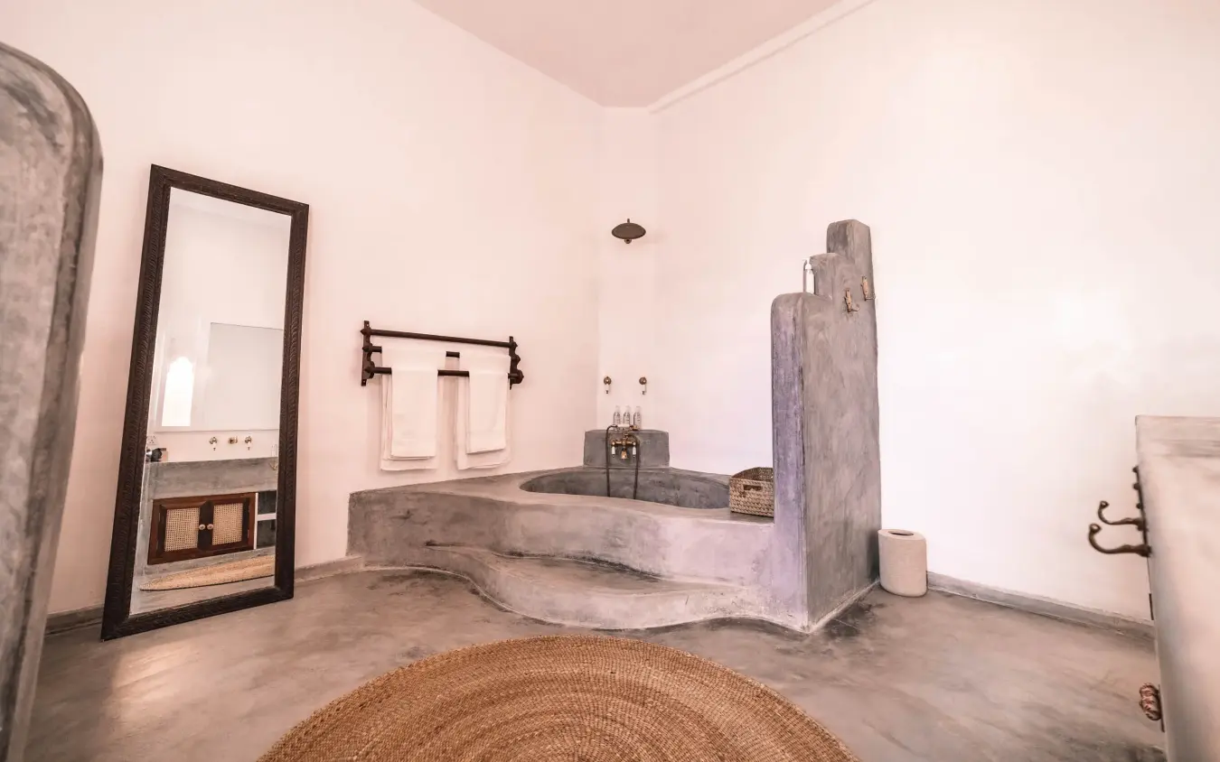 Stone bathtub in minimalist bathroom with rustic decor, The Fort, Lamu Archipelago, Kenya