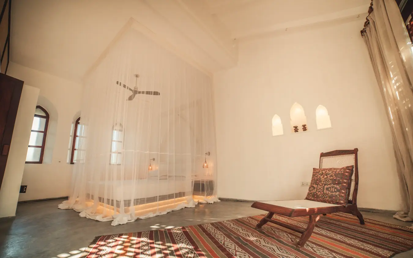 Spacious bedroom with four-poster bed and traditional textiles, The Fort, Lamu Archipelago, Kenya