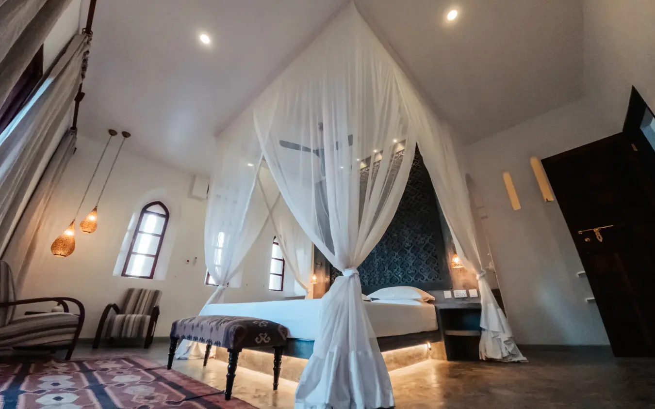 Bedroom with white canopy bed and vaulted ceiling, The Fort, Lamu Archipelago, Kenya