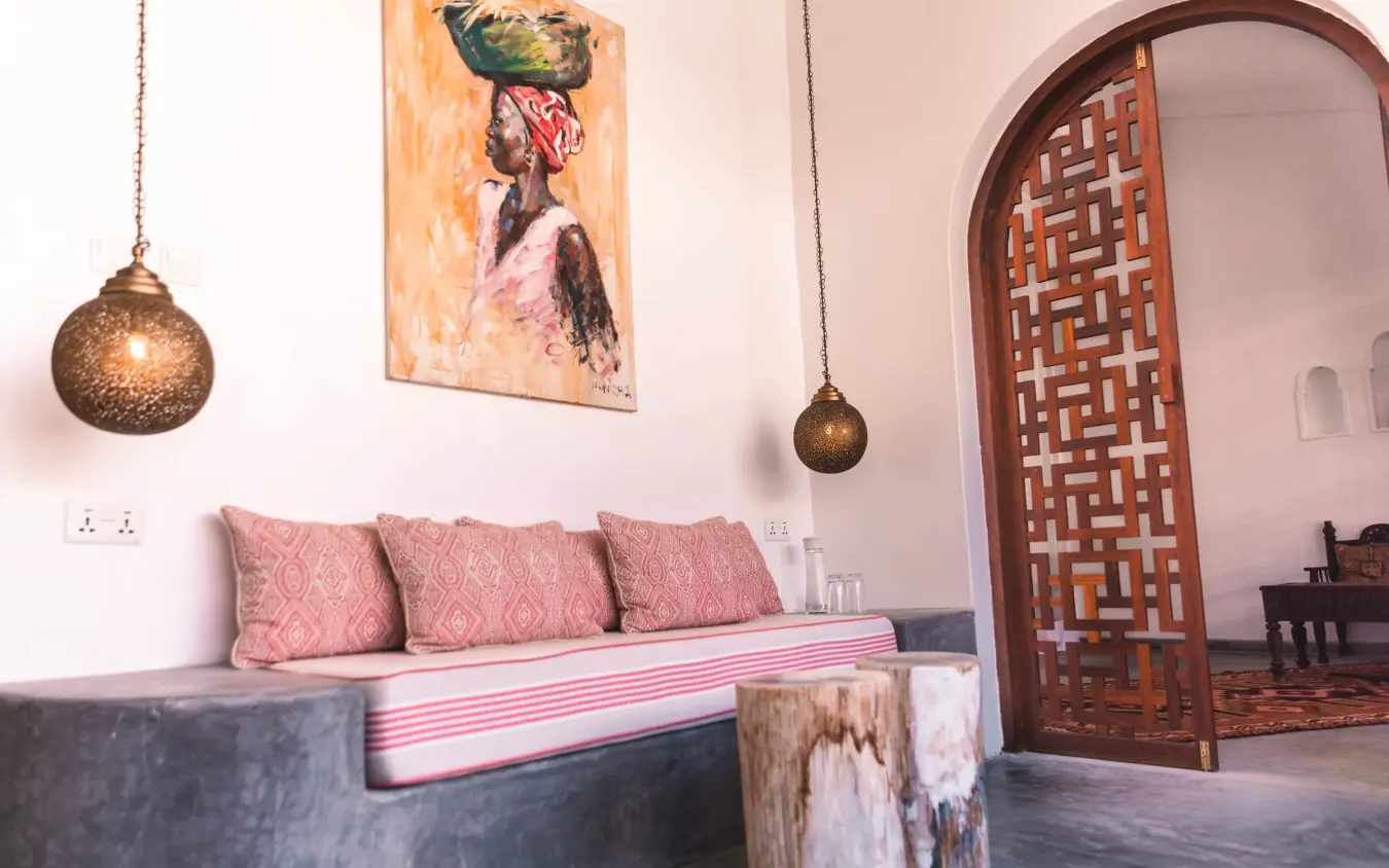 Interior seating area with pink cushions and wooden door, The Fort, Lamu Archipelago, Kenya