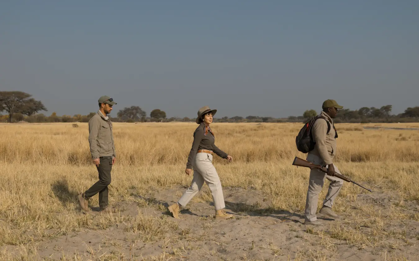 Guided walking safari group on grassland savanna trail, The Hide, Hwange National Park, Zimbabwe