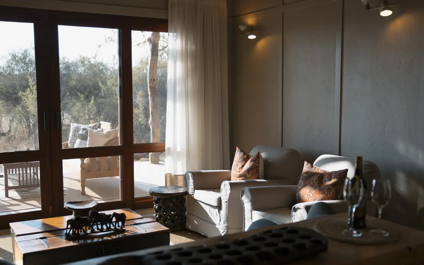 Contemporary lounge with panoramic windows overlooking woodland landscape, The Hide, Hwange National Park, Zimbabwe