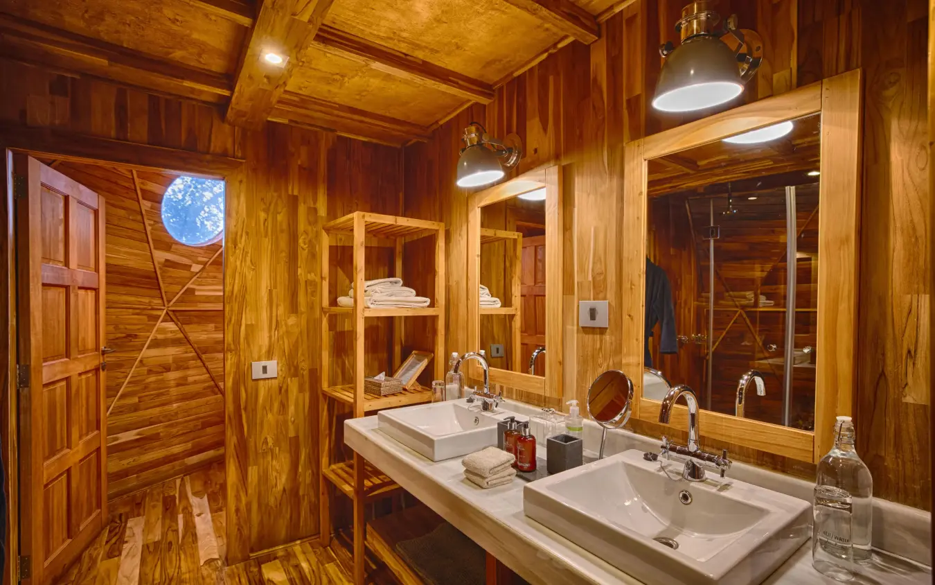 Luxury wooden bathroom with dual sinks and large mirror, The Highlands, Ngorongoro Crater, Tanzania