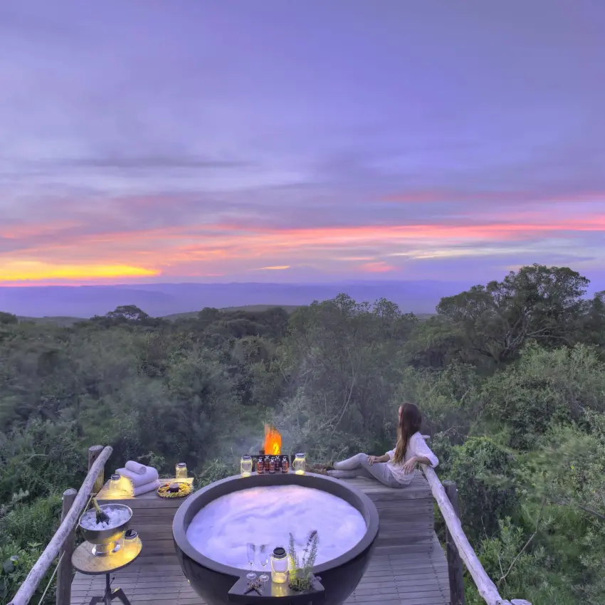 Elevated wooden deck with hot tub overlooking forest at sunset, The Highlands, Ngorongoro Crater, Tanzania