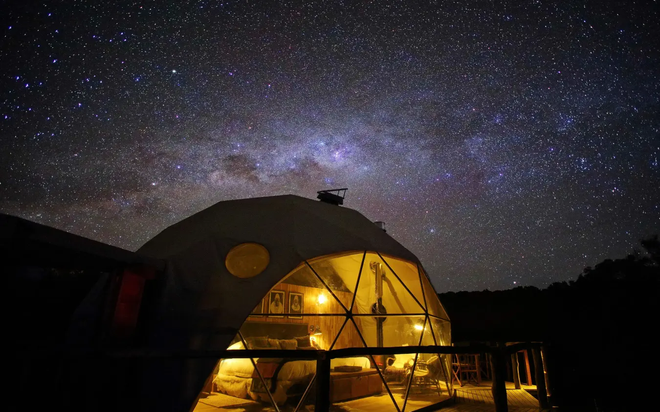 Illuminated geodesic dome beneath starry night sky, The Highlands, Ngorongoro Crater, Tanzania