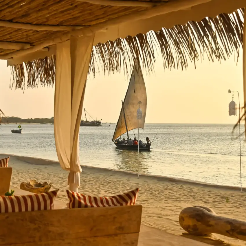 Beachfront pavilion overlooking traditional sailing boats at sunset, The Majlis Resort, Lamu Archipelago, Kenya