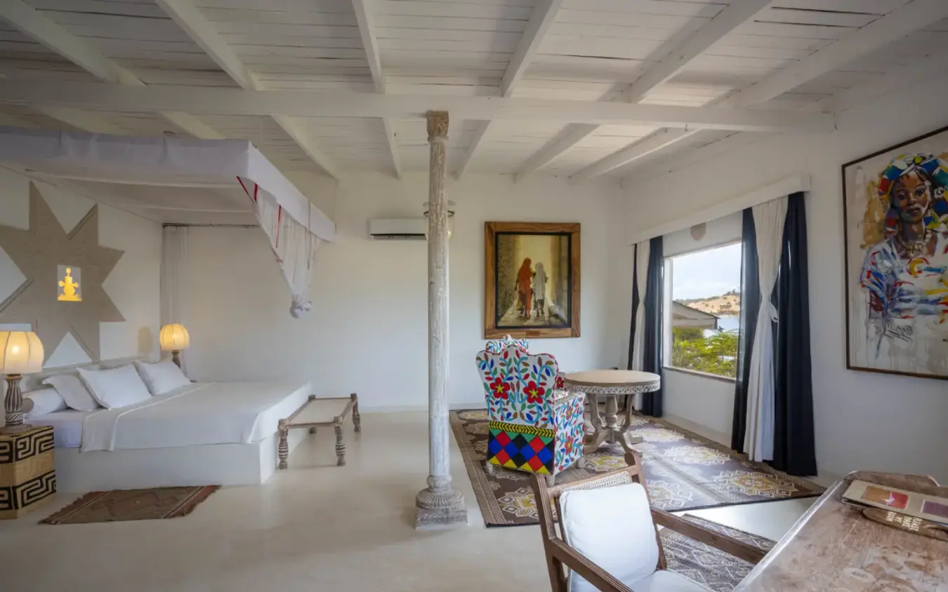 Spacious bedroom with white walls and decorative pillars, The Majlis Resort, Lamu Archipelago, Kenya