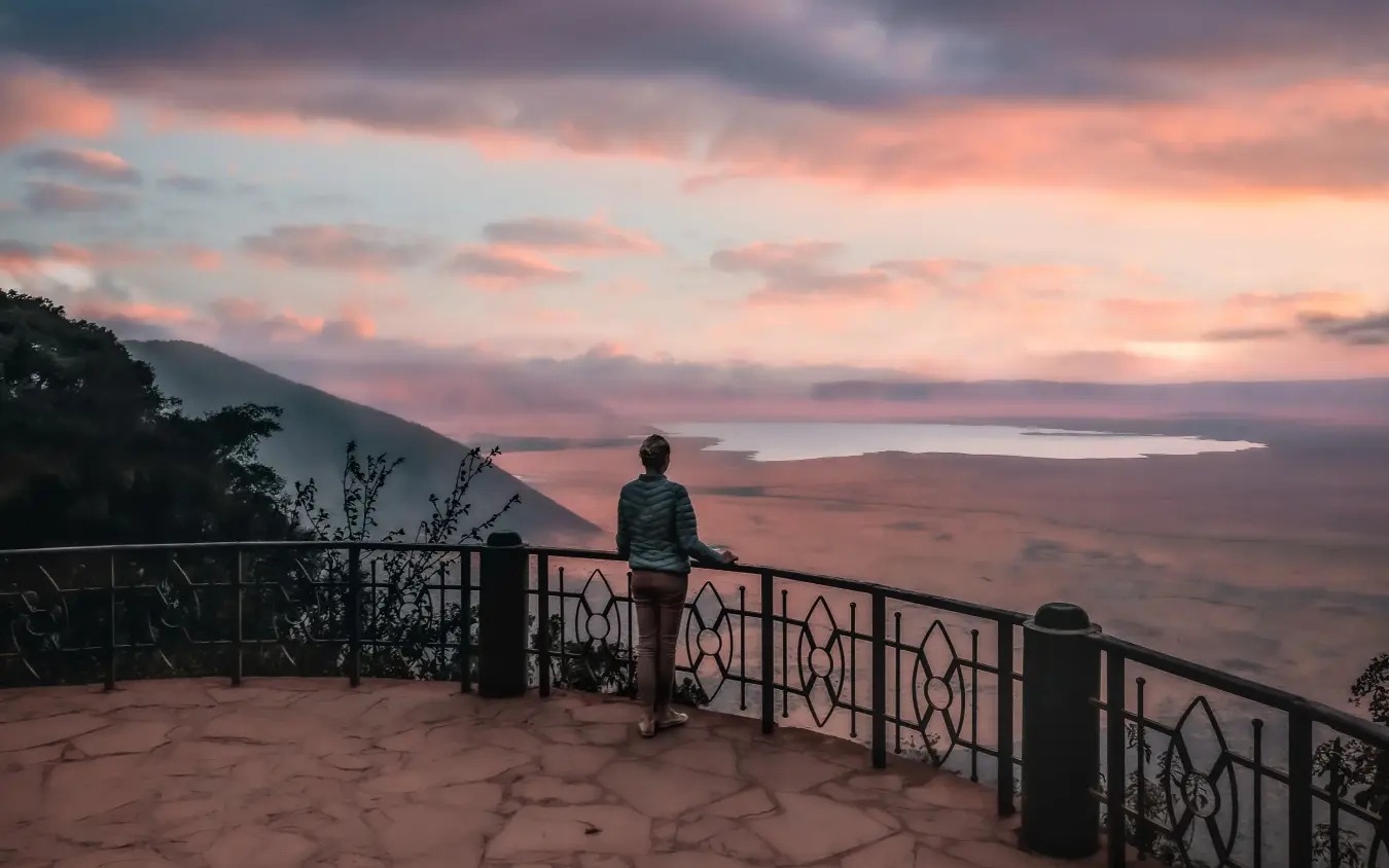Traveler at viewpoint overlooking volcanic landscape at sunset, The Manor at Ngorongoro, Ngorongoro Crater, Tanzania