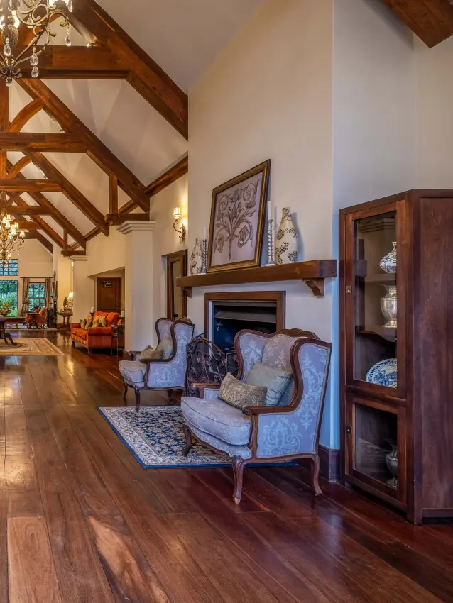 Elegant interior lodge with exposed timber beams and formal seating areas, The Manor at Ngorongoro, Ngorongoro Crater, Tanzania