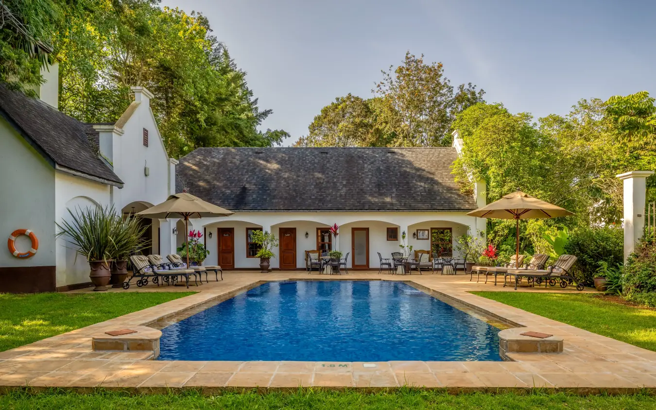 Pool with colonial-style lodge buildings and manicured grounds, The Manor at Ngorongoro, Ngorongoro Crater, Tanzania