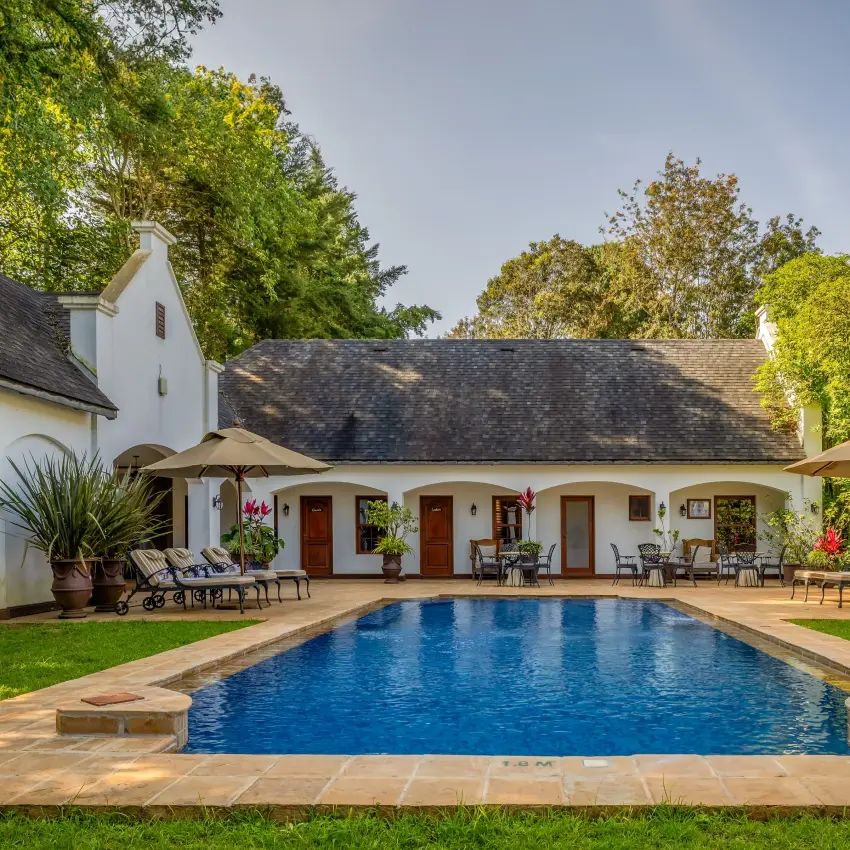 Pool with colonial-style lodge buildings and manicured grounds, The Manor at Ngorongoro, Ngorongoro Crater, Tanzania
