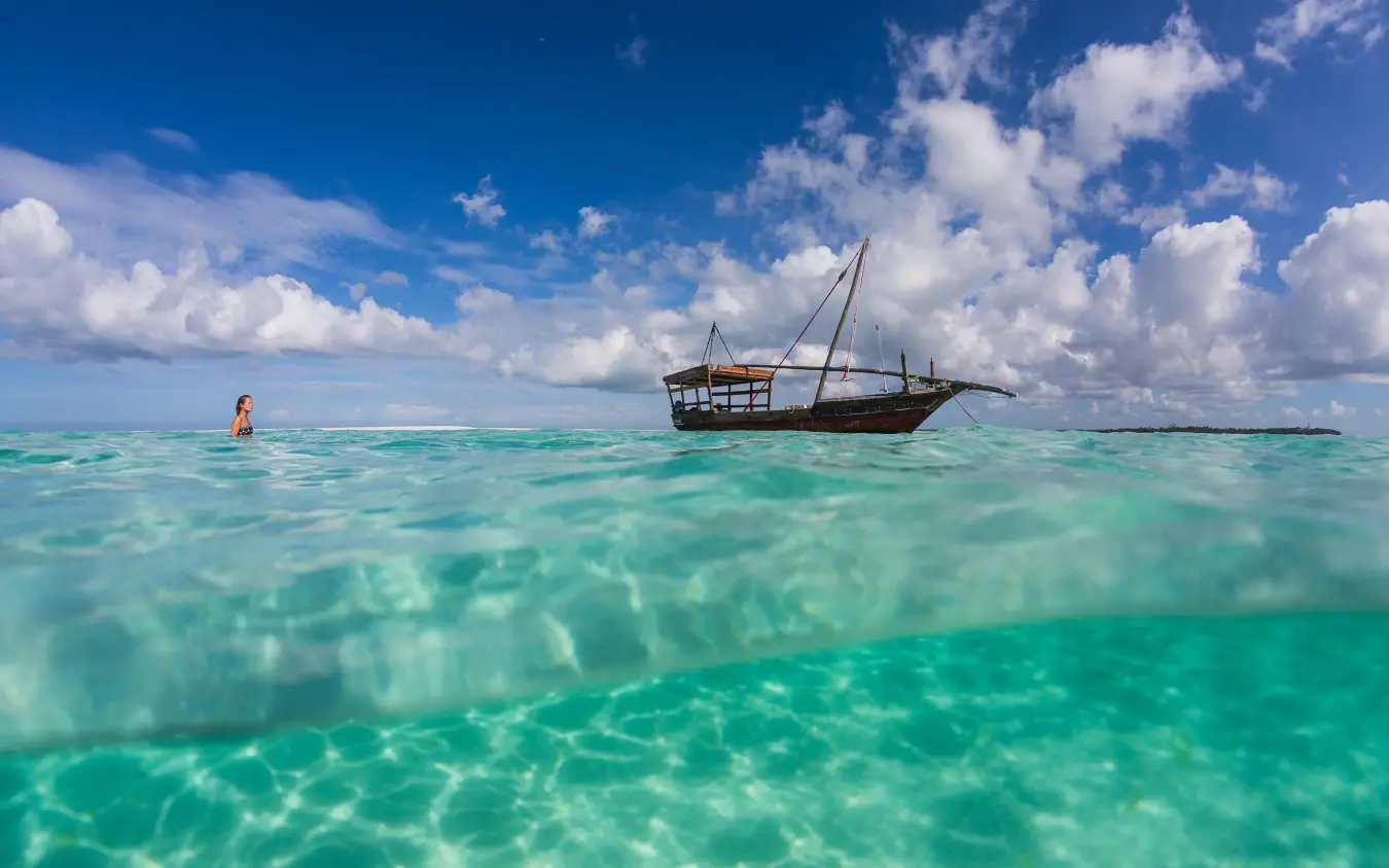 Traditional sailing dhow anchored in turquoise tropical waters, The Manta Resort, Zanzibar & Pemba, Tanzania
