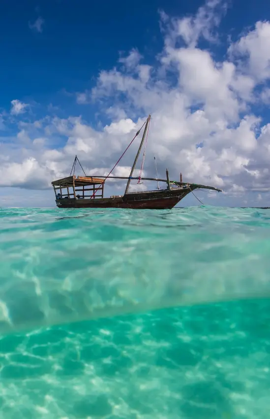 Traditional sailing dhow anchored in turquoise tropical waters, The Manta Resort, Zanzibar & Pemba, Tanzania