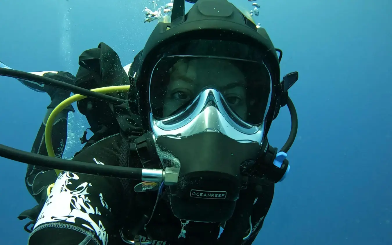 Scuba diver in full gear smiling at camera underwater, The Manta Resort, Zanzibar & Pemba, Tanzania