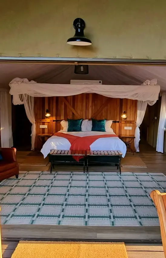Bedroom interior with double bed viewed from deck, The Wallow Lodge, Hwange National Park, Zimbabwe