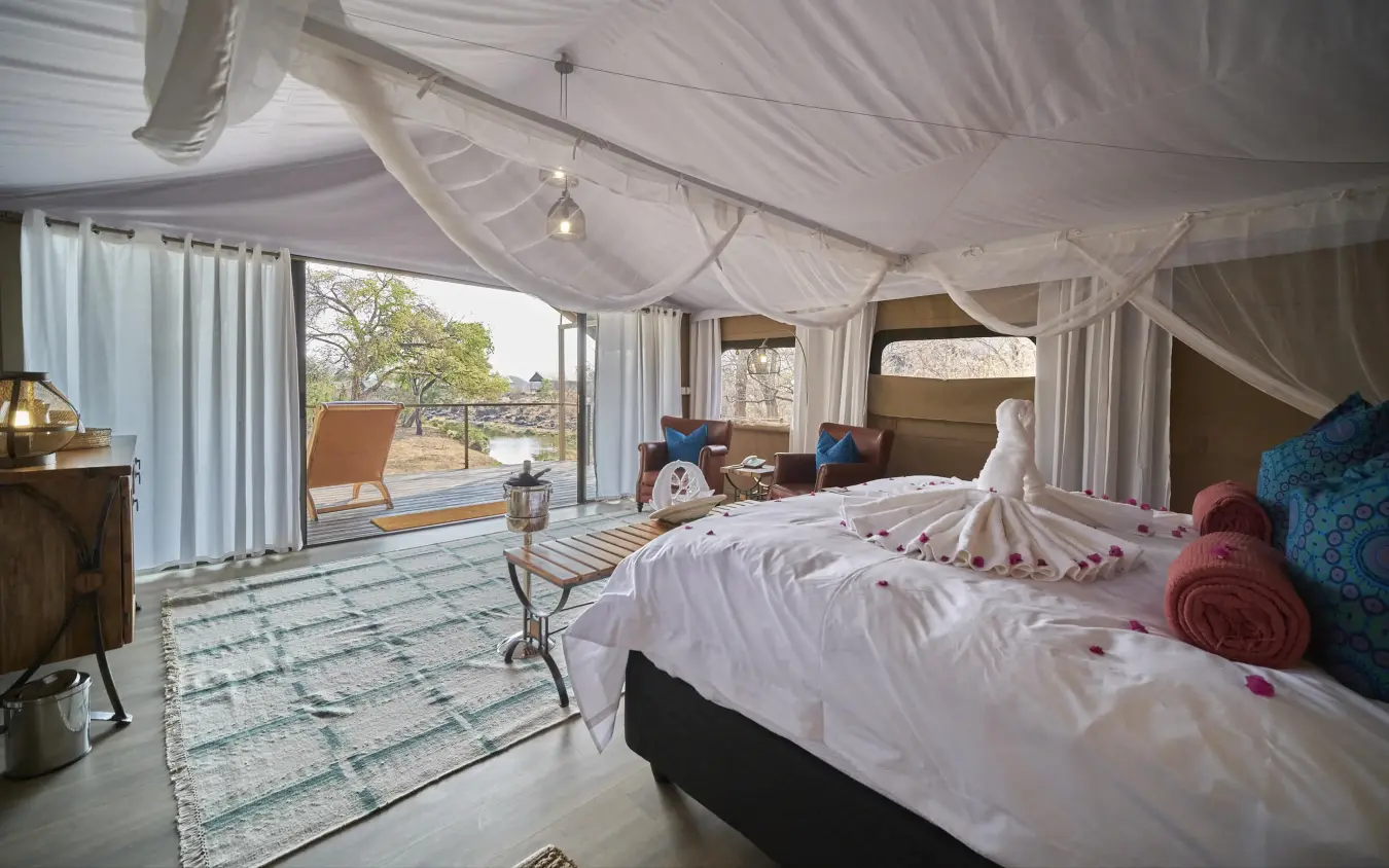 Spacious safari tent bedroom with draped ceiling and outdoor views, The Wallow Lodge, Hwange National Park, Zimbabwe