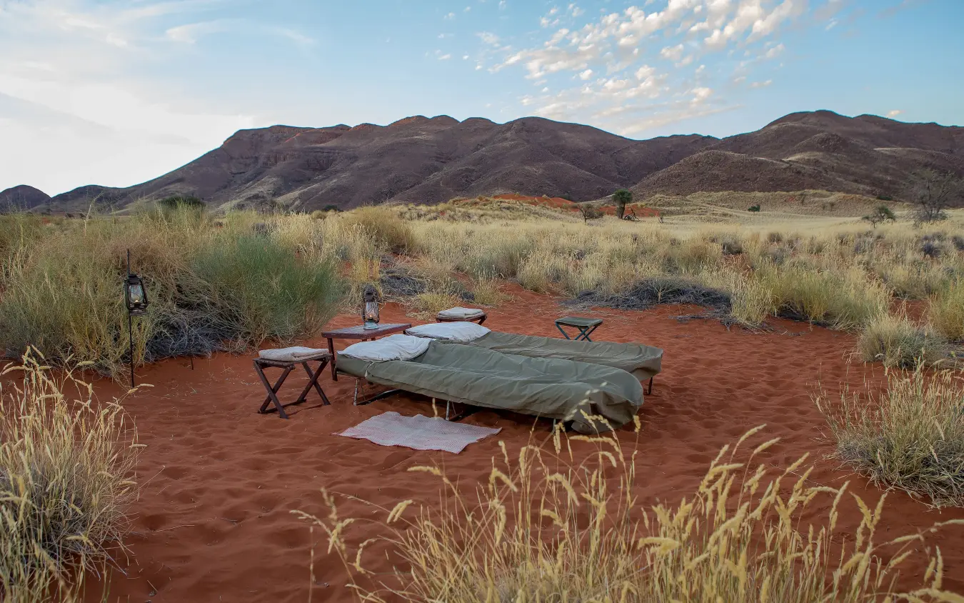 Bedroll camp setup in arid savanna landscape at dusk, Tok Tokkie Trails, NamibRand Private Reserve, Namibia