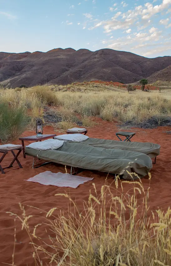 Bedroll camp setup in arid savanna landscape at dusk, Tok Tokkie Trails, NamibRand Private Reserve, Namibia