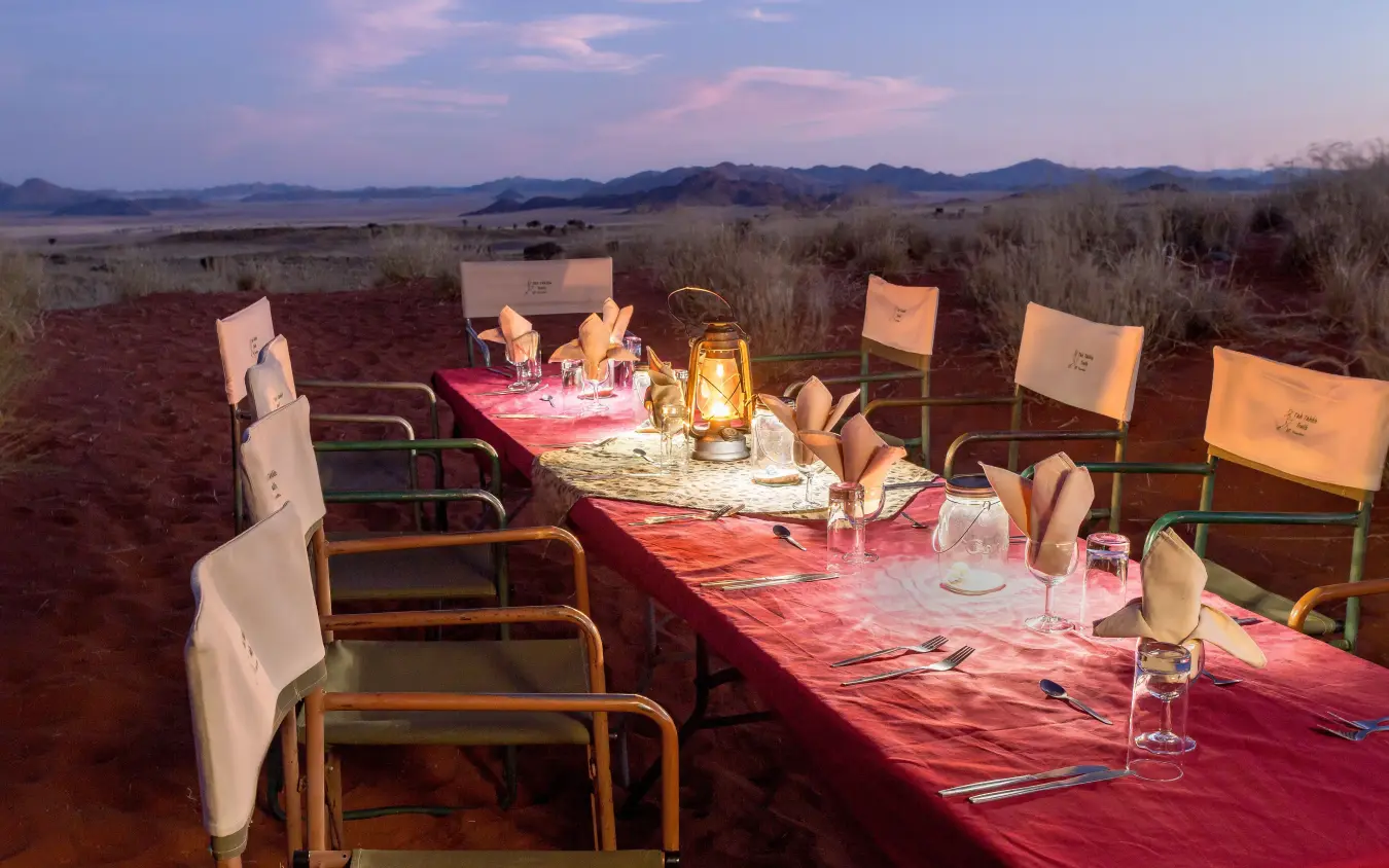 outdoor dinner table set up in wilderness at dusk, Tok Tokkie Trails, NamibRand Private Reserve, Namibia
