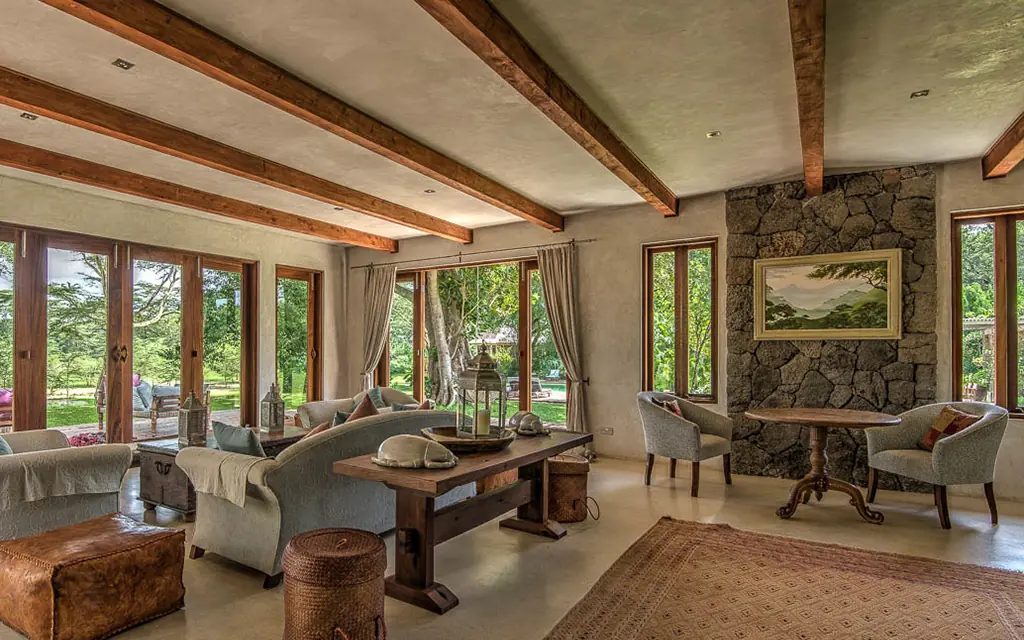 Spacious lounge with exposed beams and expansive windows overlooking grounds, Umani Springs, Amboseli and Chyulu Hills, Kenya