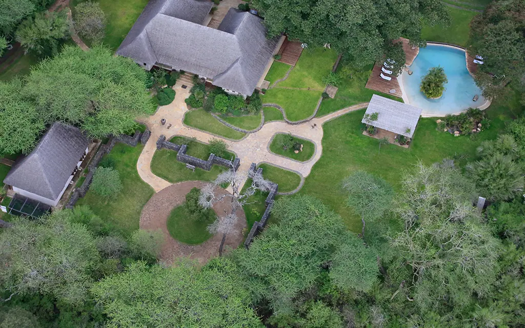 Aerial view of lodge grounds with pool and surrounding forest, Umani Springs, Amboseli and Chyulu Hills, Kenya