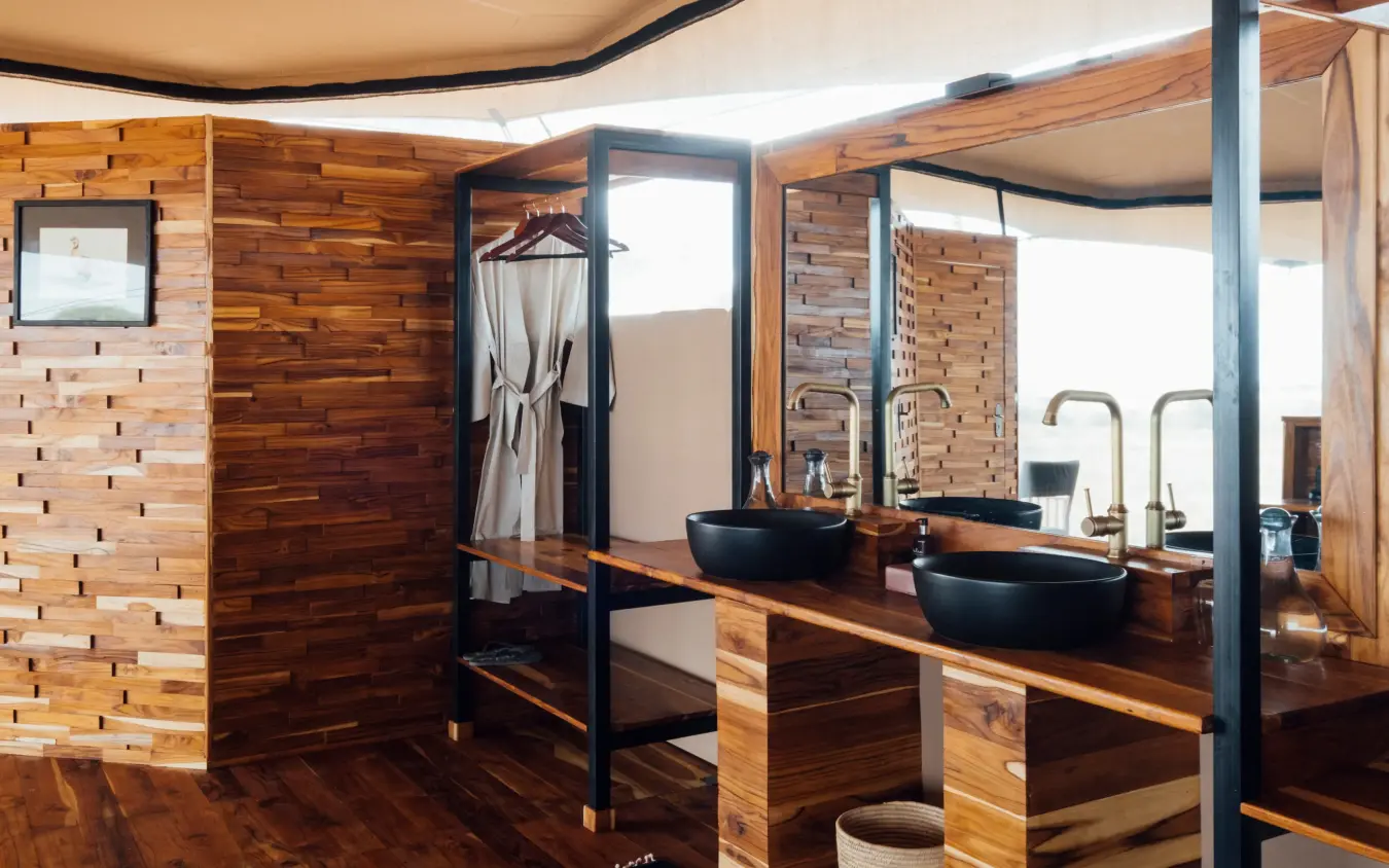 Bathroom with wooden finishes and double vessel sinks, Usangu Expedition Camp, Ruaha National Park, Tanzania