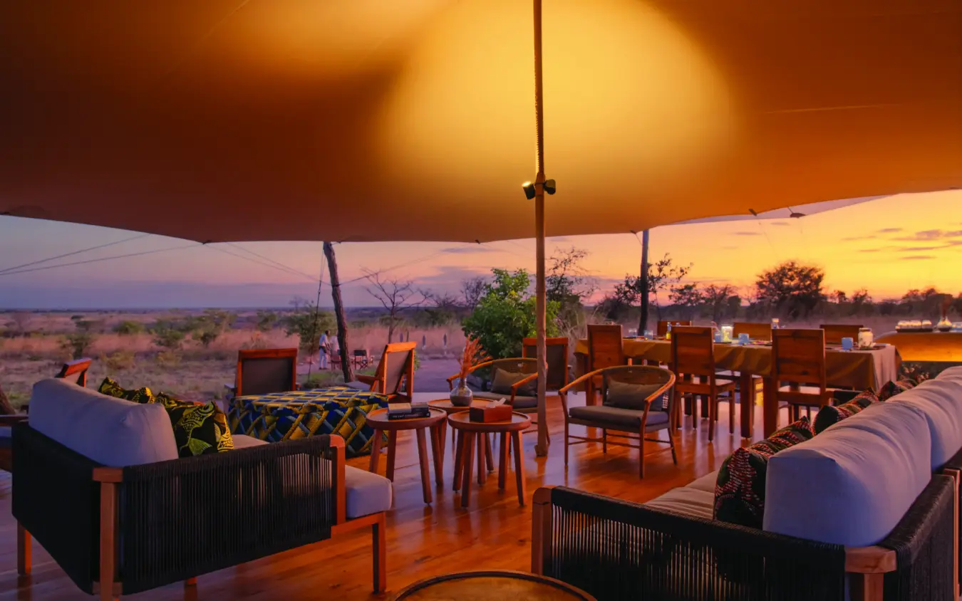 Open-air dining deck overlooking savanna at sunset, Usangu Expedition Camp, Ruaha National Park, Tanzania