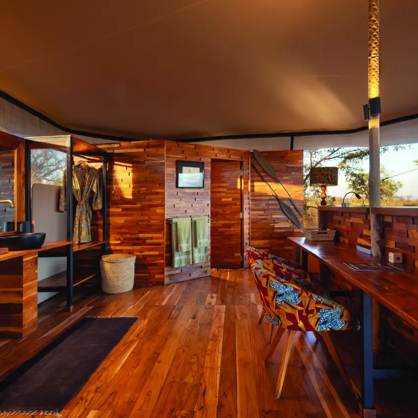 Interior of safari lodge with wooden furnishings and open views, Usangu Expedition Camp, Ruaha National Park, Tanzania