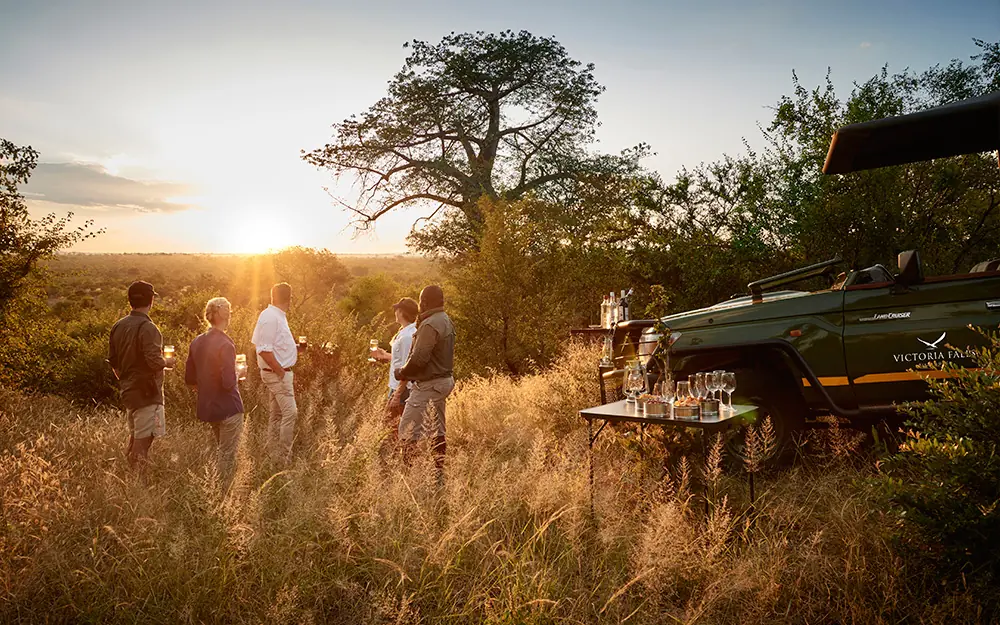 Guests enjoy sunset drinks in the African bush, Island Treehouse Suites, Victoria Falls, Zimbabwe
