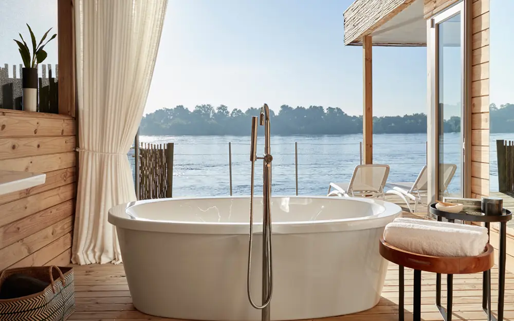 Outdoor bathtub on wooden deck overlooking river, Island Treehouse Suites, Victoria Falls, Zimbabwe