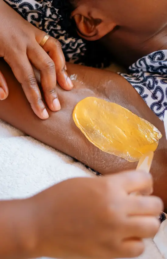 Child's hand touching golden body treatment on adult's arm during spa, Villa Kigali, Kigali, Rwanda