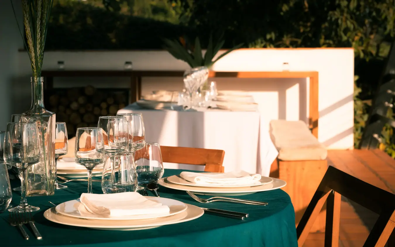 Elegant outdoor dining setup with teal tablecloth and glassware, Villa Kigali, Kigali, Rwanda