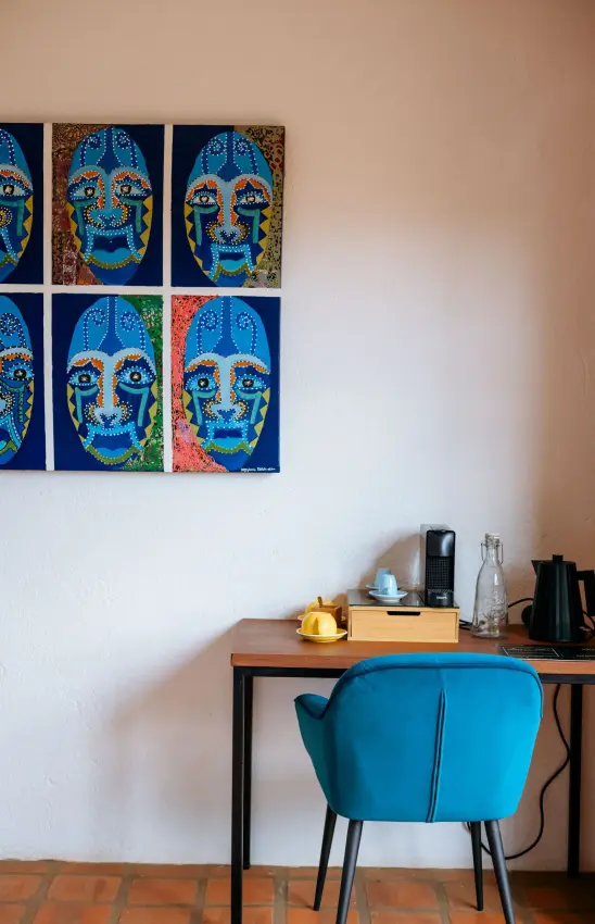 Modern workspace with blue chair and colorful skull artwork, Villa Kigali, Kigali, Rwanda
