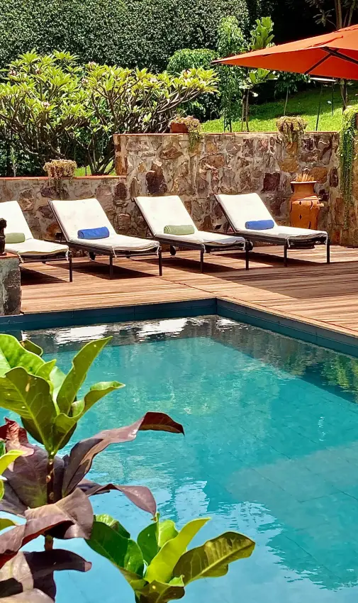 Swimming pool with loungers and stone wall backdrop, Villa Kigali, Kigali, Rwanda