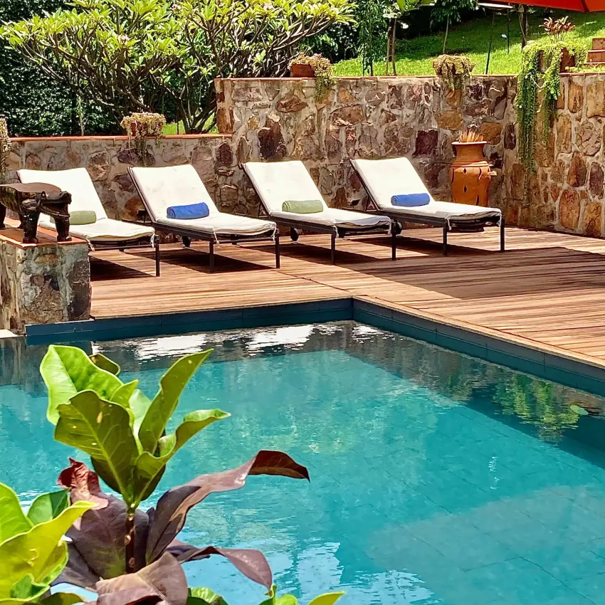 Swimming pool with loungers and stone wall backdrop, Villa Kigali, Kigali, Rwanda
