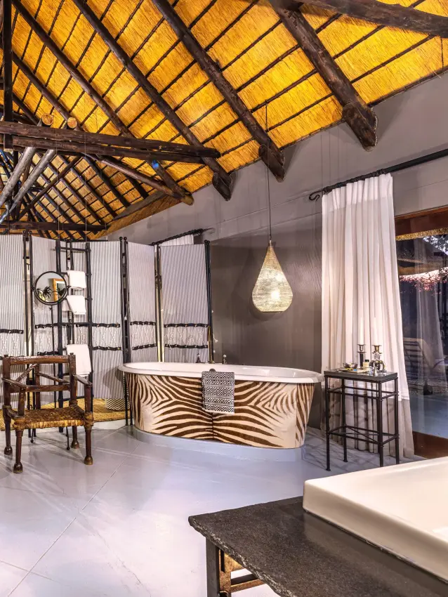 Luxury safari lodge interior with thatch ceiling and zebra-print furnishings, Villa Mushara, Etosha National Park, Namibia