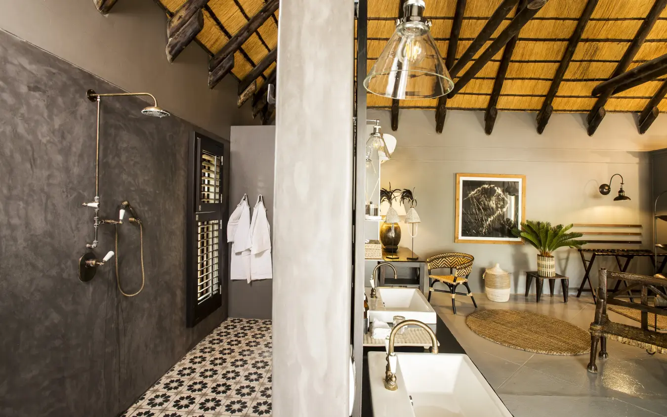Luxury safari lodge bathroom with dark tile shower and patterned floor tiles, Villa Mushara, Etosha National Park, Namibia