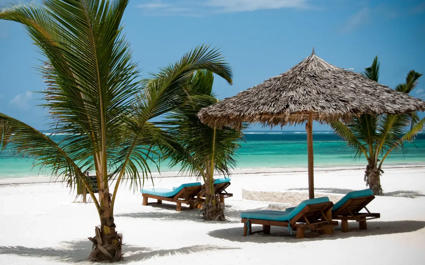 Beach loungers under thatched umbrellas with palm trees, Waterlovers Beach Resort, Diani Beach, Kenya