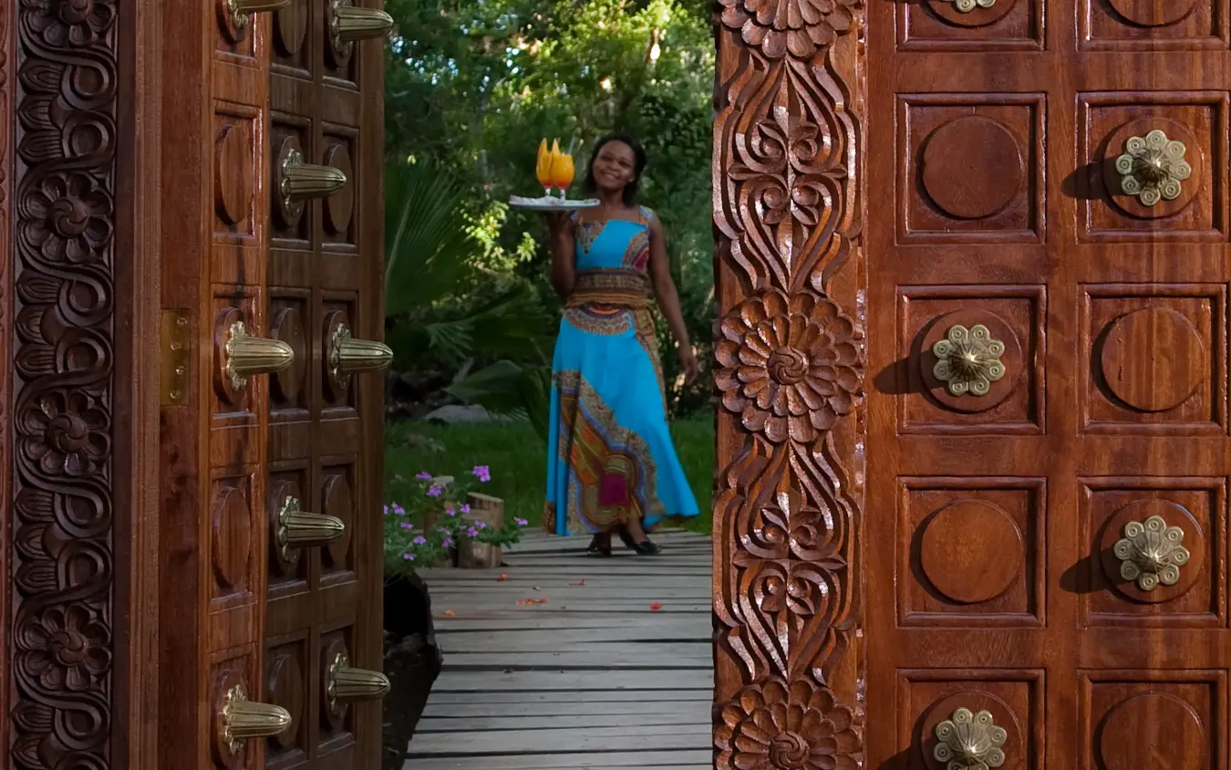 Ornate wooden doors opening to wooden deck pathway, Waterlovers Beach Resort, Diani Beach, Kenya