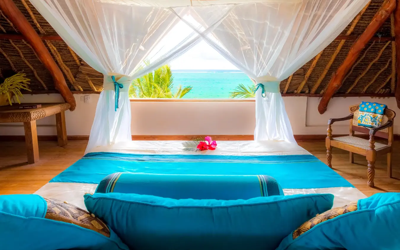 Oceanfront bedroom with sheer canopy overlooking turquoise water, Waterlovers Beach Resort, Diani Beach, Kenya