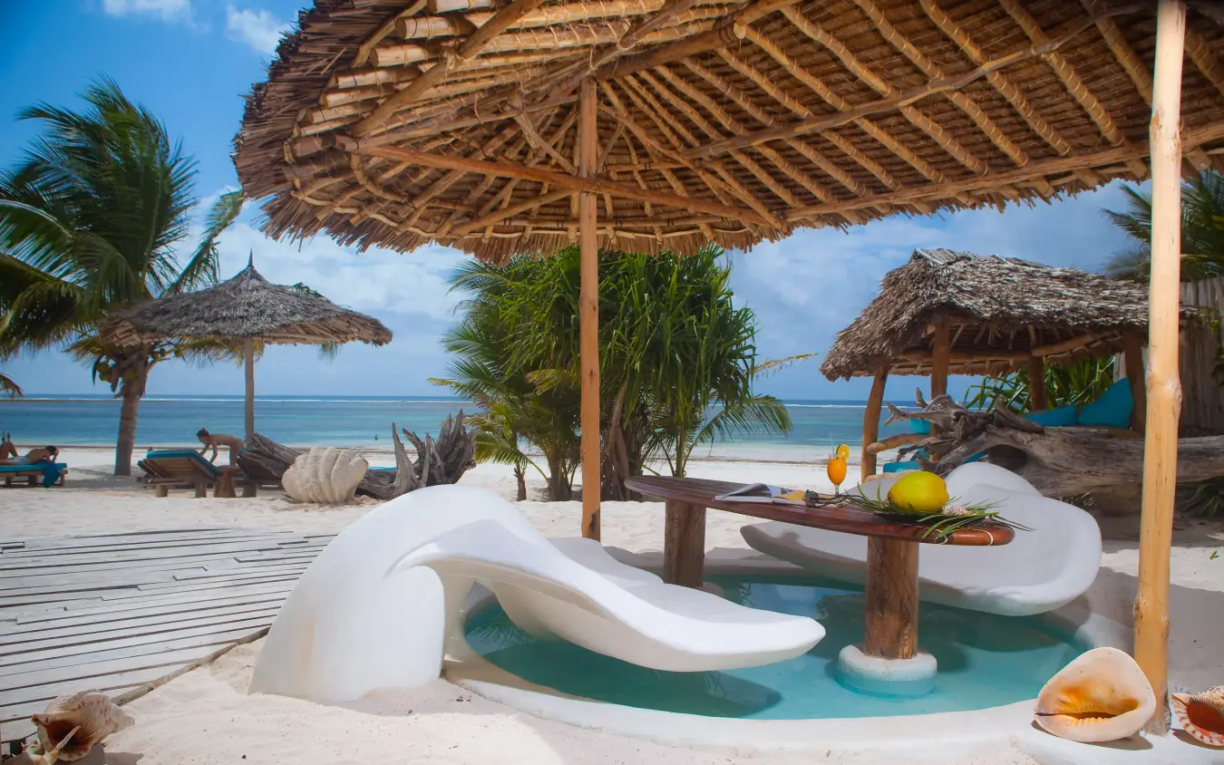 Curved white pool with thatched umbrellas on sandy beach, Waterlovers Beach Resort, Diani Beach, Kenya