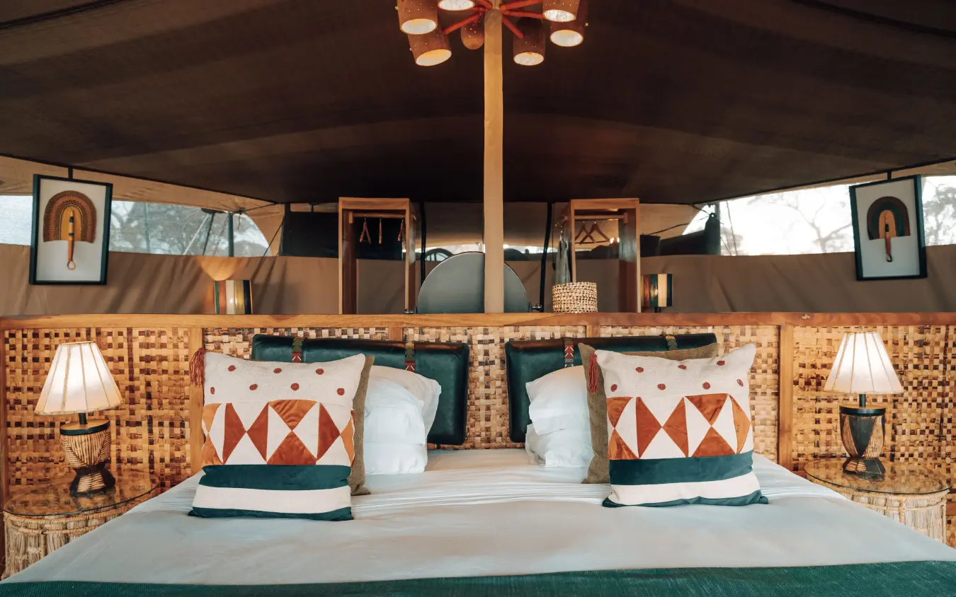Luxury safari tent bedroom with patterned pillows and green accents, Serengeti Green Camp, Serengeti National Park, Tanzania