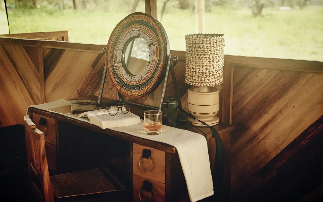 Wooden desk with mirror, glasses, and woven basket decor, Serengeti Green Camp, Serengeti National Park, Tanzania