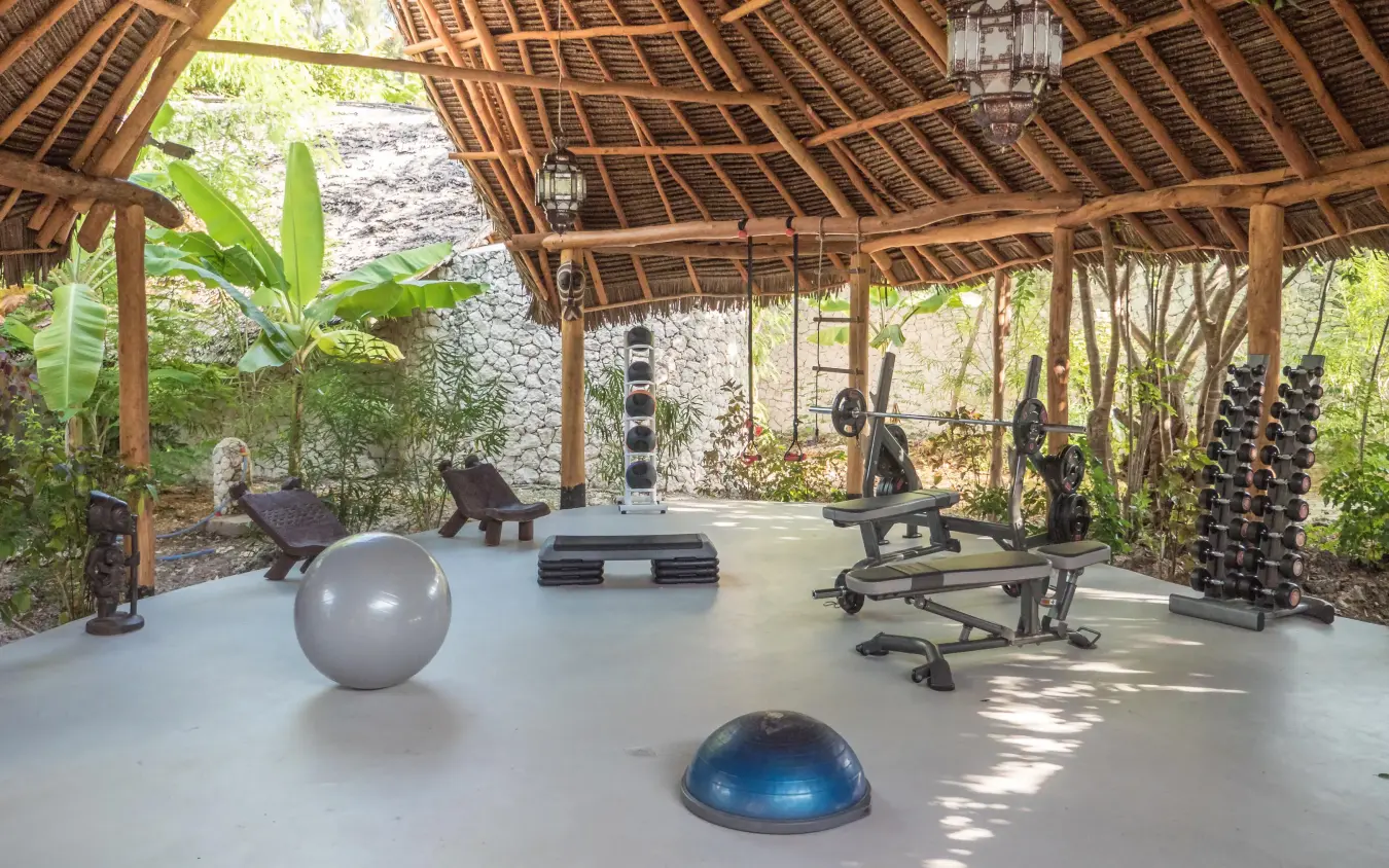 Fitness studio with exercise equipment under wooden pavilion, White Sand Luxury Villas & Spa, Zanzibar & Pemba, Tanzania