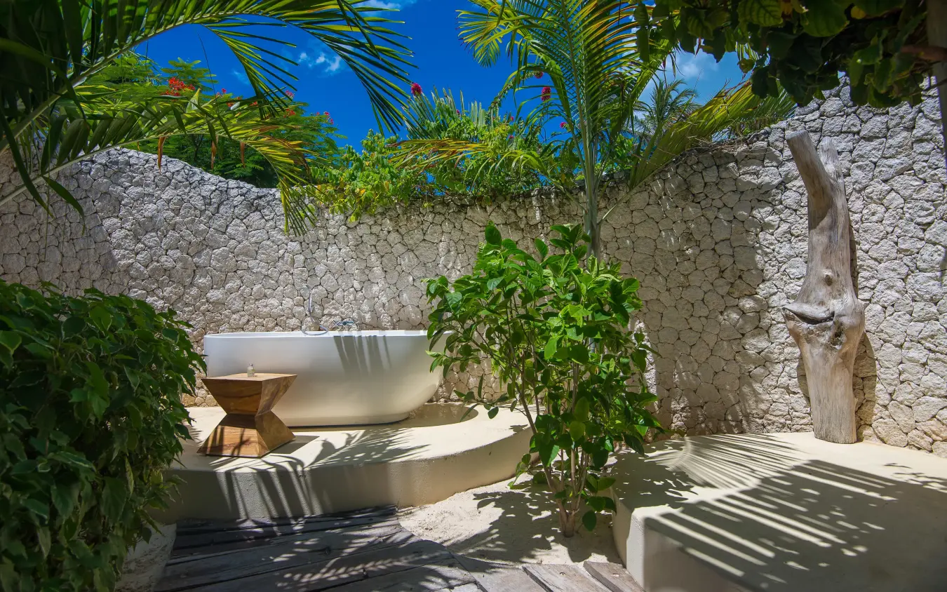 Outdoor spa area with stone walls and tropical plants, White Sand Luxury Villas & Spa, Zanzibar & Pemba, Tanzania